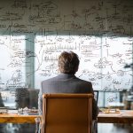 تصویر یک مدیر در حال بررسی برنامه های کوچینک مدیریتی خود